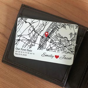 Puede incluir: Una tarjeta de cartera personalizada con un mapa, un marcador de corazón rojo y el texto "Our First Date". La tarjeta también incluye los nombres "Emily" y "Jacob" con un símbolo de corazón y la fecha 15 de marzo de 2025.