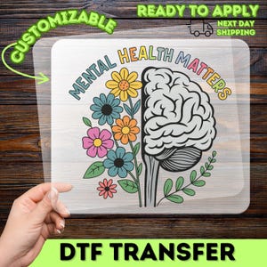 May include: A clear DTF transfer sheet featuring a graphic design with the text MENTAL HEALTH MATTERS. The design shows a human brain on the right side and a collection of colorful flowers including yellow, blue, pink, and orange petals on the left.