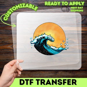 May include: A DTF transfer with a wave design and a setting sun. The wave is in blue and black, with white highlights. The transfer is ready to apply and customizable. The image also includes the text 'Next Day Shipping'.