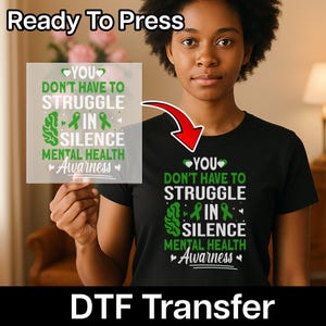 May include: A black t-shirt featuring a white and green graphic print that reads: YOU DON'T HAVE TO STRUGGLE IN SILENCE MENTAL HEALTH Awarness. The design includes a brain icon, two awareness ribbons, and small heart accents.