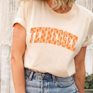 a blonde woman wearing a tennessee t - shirt
