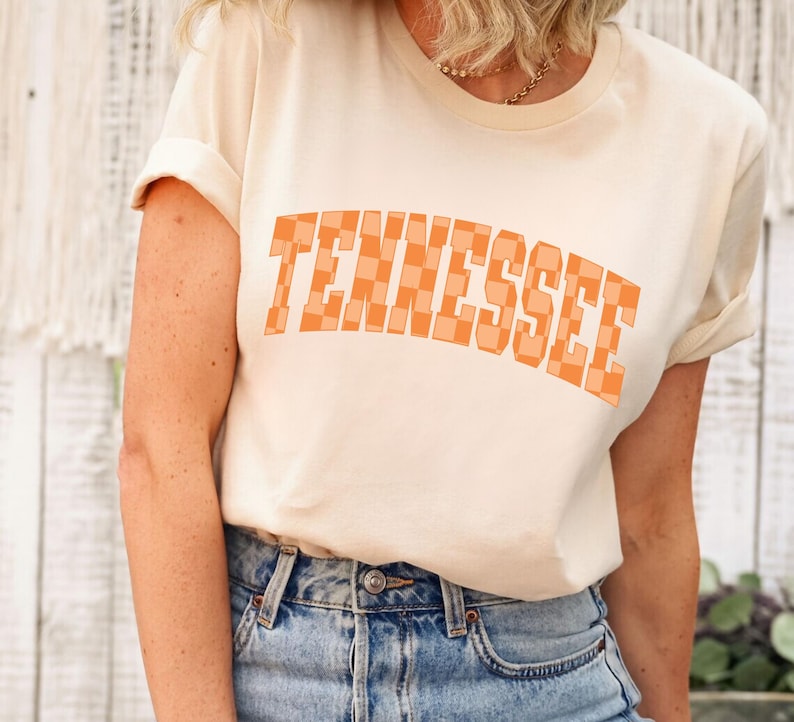 a blonde woman wearing a tennessee t - shirt
