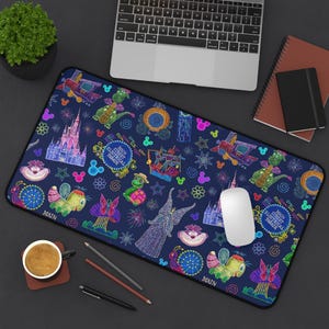 May include: A rectangular desk mat featuring a dark blue background with a colorful, neon-style pattern of parade floats, castles, and character icons. The design includes text reading Main Street Electrical Parade in circular emblems.