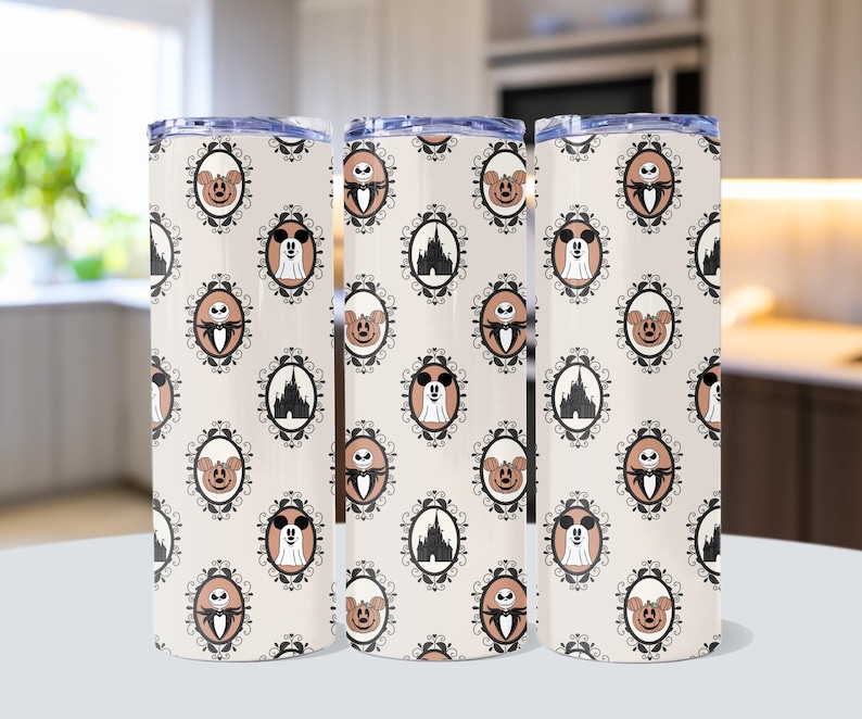 Pu&ograve; includere: Tre bicchieri isolanti bianchi con un motivo ripetuto di personaggi dei cartoni animati incorniciati e sagome di castelli in nero e marrone. I bicchieri hanno un coperchio argentato e sono su una superficie bianca.