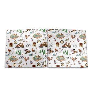 May include: A white notebook featuring a repeating pattern of Fort Wilderness logos, Chip 'n' Dale characters, Mickey and Minnie Mouse, pine trees, lanterns, compasses, acorns, and marshmallows on sticks. The design includes small hearts and birds.