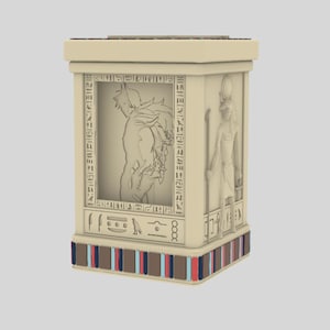 Könnte beinhalten: Eine beige, rechteckige dekorative Box mit ägyptischem Thema. Die Box zeigt geschnitzte Hieroglyphen und Figuren, darunter eine Person und eine Gottheit. Die Basis hat ein dekoratives Band mit blauen, roten und braunen Streifen.