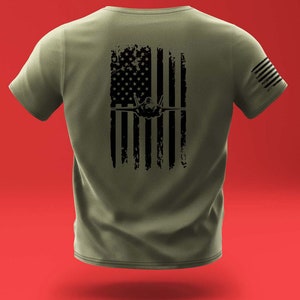 May include: A green t-shirt with a black distressed American flag design featuring a silhouette of a fighter jet.
