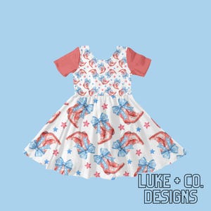 May include: A white dress with a red bodice and a print of red, white and blue cowboy boots and stars. The dress has short sleeves and a full skirt.