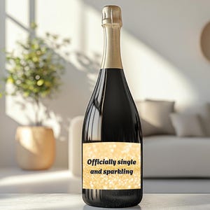 Könnte beinhalten: Eine Flasche Sekt mit einem goldenen Etikett, auf dem "Offiziell Single und prickelnd" steht.