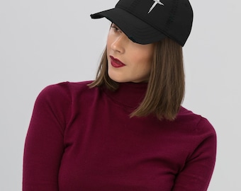 May include: Black distressed baseball cap with a white cross graphic. The cap has a curved brim and a worn appearance. The hat is made of a soft material.