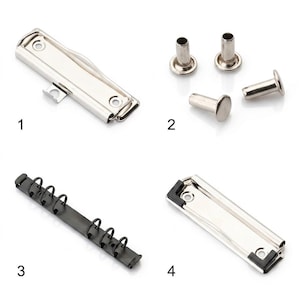 Può includere: Una collezione di accessori di cancelleria che include una clip in metallo argentato per cartelline, quattro rivetti in metallo argentato, un meccanismo a sei anelli nero e una clip in metallo argentato con angoli in gomma nera.