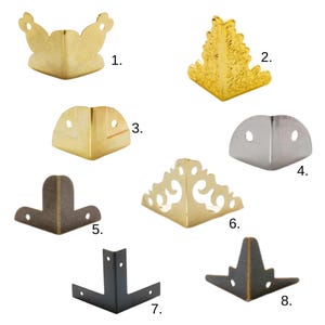 Può includere: Una collezione di otto protezioni angolari in metallo di varie forme e finiture. La selezione comprende opzioni oro, argento e nere, con design decorativi e semplici. Questi elementi hardware sono progettati per mobili e progetti artigianali.