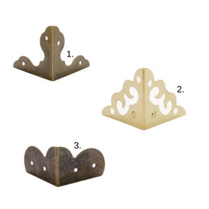 Peut inclure: Trois équerres d'angle décoratives en métal de différentes finitions. Les équerres sont dans des tons bronze et or. Chaque équerre a un design orné unique, avec des bords incurvés et des découpes décoratives. Idéal pour ajouter une touche vintage aux meubles ou à l'artisanat.
