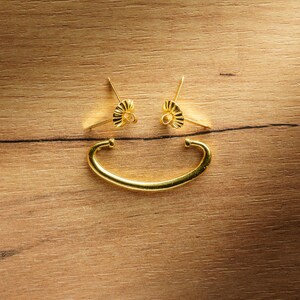 Puede incluir: Dos tiradores de cajón de metal dorado con un diseño decorativo y un tirador de metal dorado.