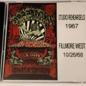 May include: A CD case with a psychedelic poster of the band "Jefferson Airplane" on the front. The poster features a green and white creature with a red background. The text "Studio Rehearsals 1967" and "Fillmore West 10/26/68" is printed on the right side of the case.