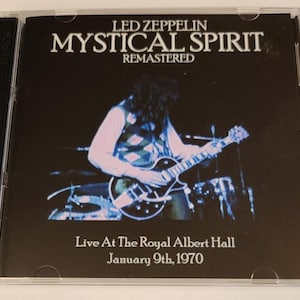 May include: A CD case with a black background and a photo of a musician playing a guitar. The text on the case reads "LED ZEPPELIN MYSTICAL SPIRIT REMASTERED Live At The Royal Albert Hall January 9th, 1970".