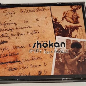 May include: A CD case with a handwritten setlist for a concert. The setlist includes the song titles "Gypsy Woman", "Isabella", "Slow Blues", and "For Lover Man". The case also features a photo of a musician playing a guitar and a photo of a musician playing a saxophone.