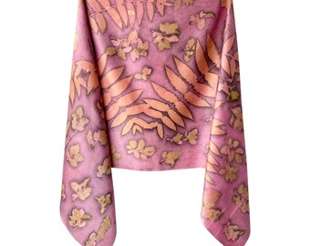 May include: A rectangular scarf in a dusty rose pink hue featuring a botanical print of various leaves and small floral shapes in lighter shades of peach and tan scattered across the fabric surface in a repeating pattern.