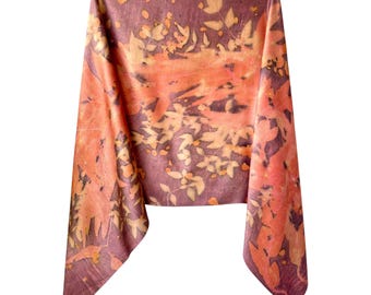 May include: A rectangular scarf featuring a botanical print with a deep plum purple background and overlapping leaf patterns in shades of orange, peach, and light yellow. The fabric displays a natural, organic texture with varied leaf shapes.