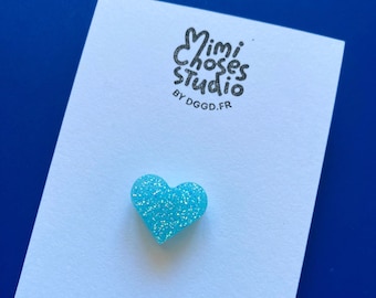 Pequeño pin de corazón con purpurina azul neón