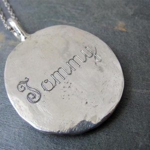 K&ouml;nnte beinhalten: Silberne Halskette mit Anh&auml;nger, auf dem der Name "Sammy" in einer kursivschriftlichen Schriftart graviert ist.