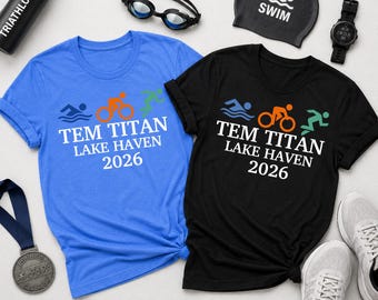 May include: A blue and a black t-shirt featuring a triathlon graphic with the text TEM TITAN LAKE HAVEN 2026. Accessories include a black water bottle, swimming goggles, a black swim cap with the word SWIM, a digital watch, a medal, and white sneakers.