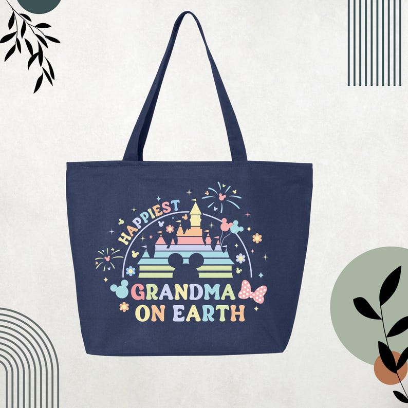 May include: Navy blue tote bag featuring the text "Happiest Grandma on Earth" in a colourful design. The graphic includes a castle, fireworks, and Mickey Mouse silhouettes. The bag has two long handles.