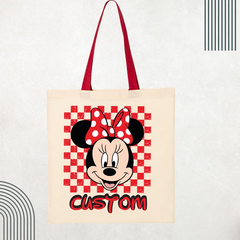 May include: A cream-colored tote bag with red handles featuring a graphic of Minnie Mouse wearing a red and white polka dot bow. The character is centered over a red and white checkered square pattern with the word CUSTOM printed in red below.