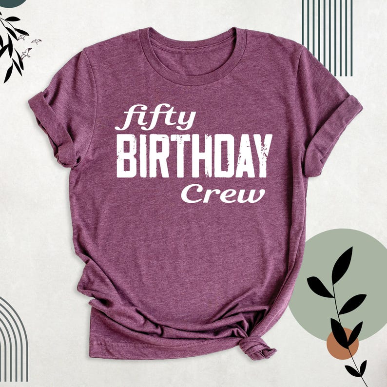 May include: A purple t-shirt with the text "fifty birthday crew" in white.
