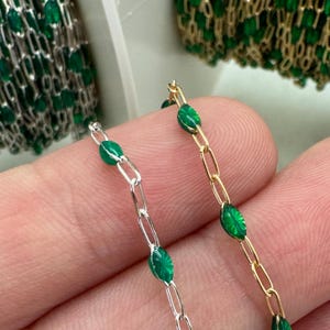 May include: Two strands of chain with green glass beads. One chain is silver and the other is gold.