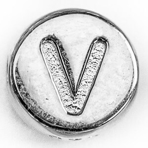 May include: A silver-coloured metal charm with the letter V embossed on it.