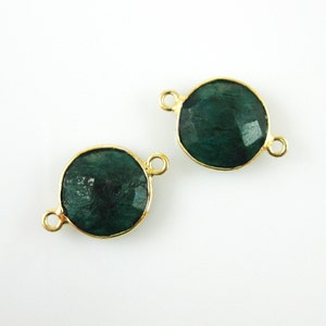 May include: Two gold-toned round connector charms with a dark green gemstone in the center. The charms have two loops on the side for attaching to jewelry.