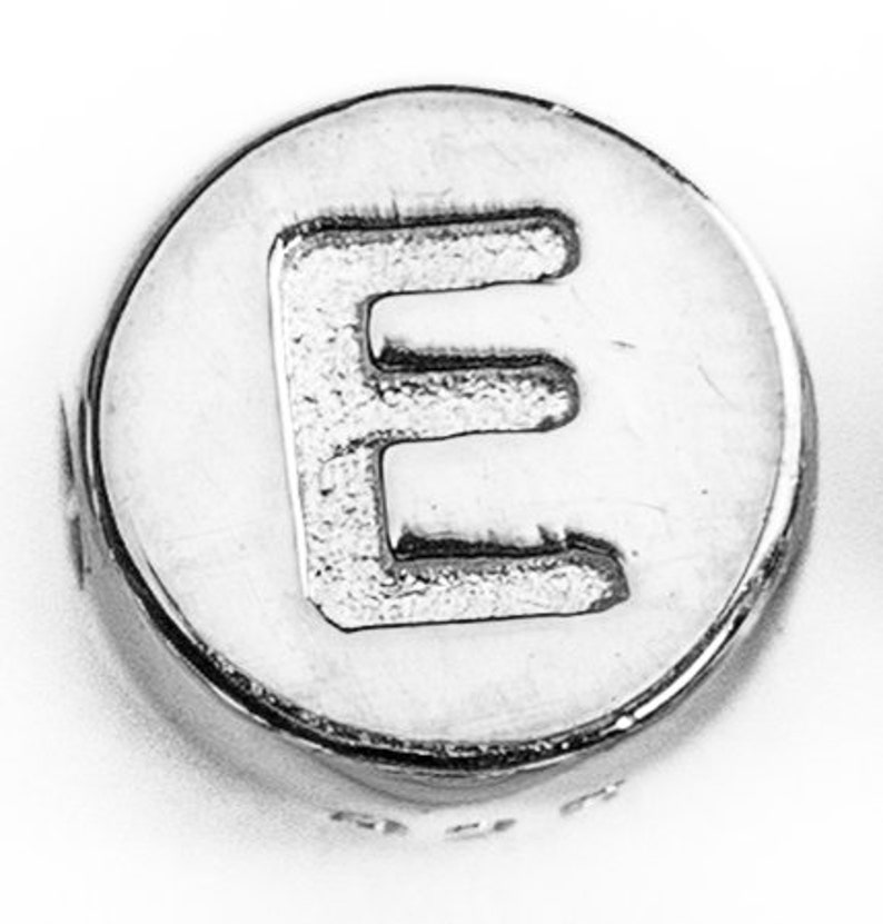 May include: Silver charm bead with the letter E embossed on the front.