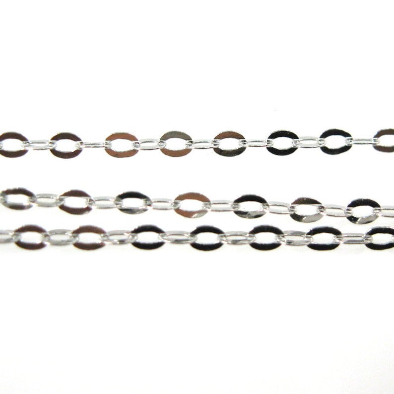 May include: Silver chain with oval links. The chain is laid out in three rows on a white background.