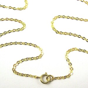 May include: A gold chain necklace with a lobster clasp closure. The chain is made of small, oval-shaped links.