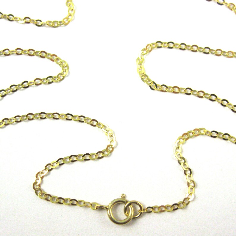 May include: A gold chain necklace with a lobster clasp closure. The chain is made of small, oval-shaped links.
