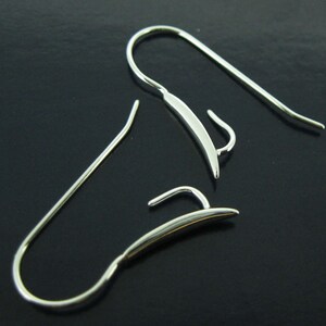 May include: Two silver earring hooks, one with a curved hook and the other with a straight hook.
