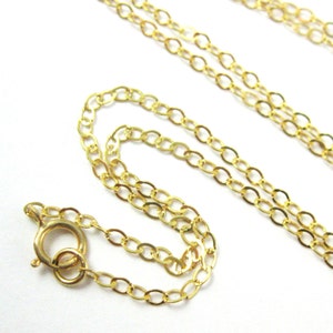 May include: A gold chain necklace with a lobster clasp closure. The chain is made of oval links.