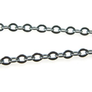 May include: A close-up of a silver chain with oval links. The chain is lying flat on a white surface.