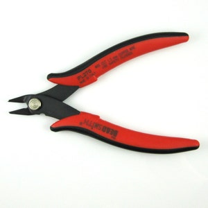 May include: Red and black wire cutters with a black handle and a red handle. The cutters are labeled "Beadsmith" and "PL270 Made in Italy. Max Cut 1.3 mm Copper Wire. Use Safety Glasses."