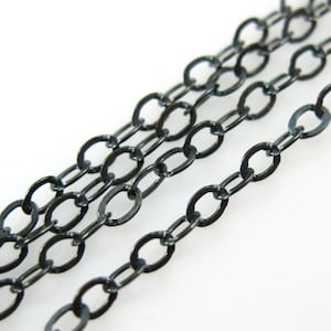 May include: Black chain with oval links. The chain is made of metal and has a dark, oxidized finish.