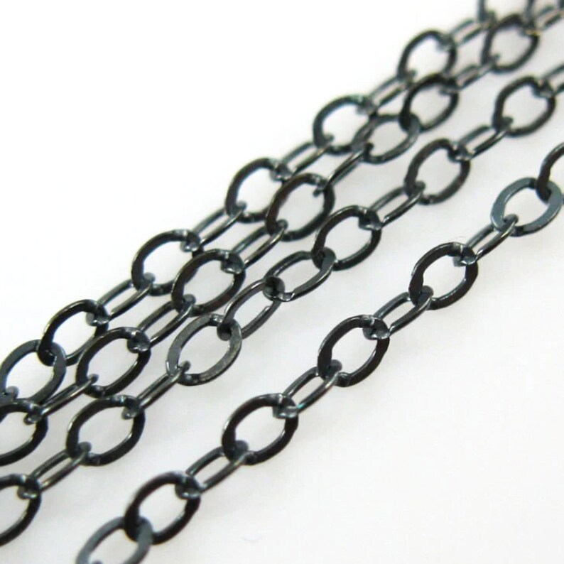 May include: Black chain with oval links. The chain is made of metal and has a dark, oxidized finish.