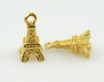 May include: Two gold-colored Eiffel Tower charms with a loop at the top for attaching to jewelry or other crafts.