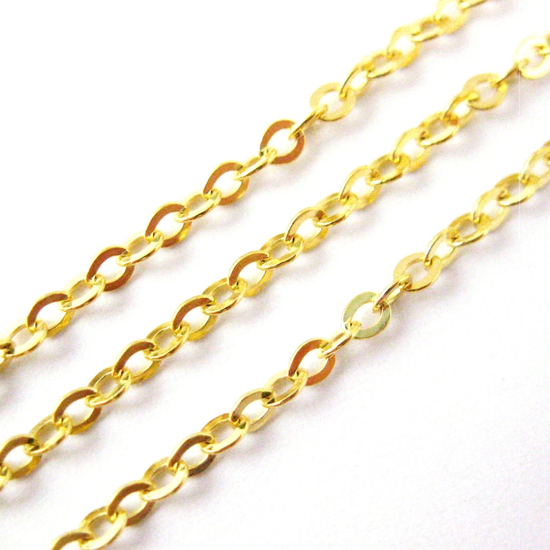 May include: Gold chain with oval links. The chain is shown in three rows, with the top row being the furthest away from the camera.