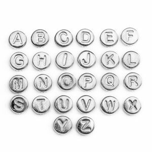 May include: Silver alphabet letter beads, each bead features a letter of the alphabet from A to Z.