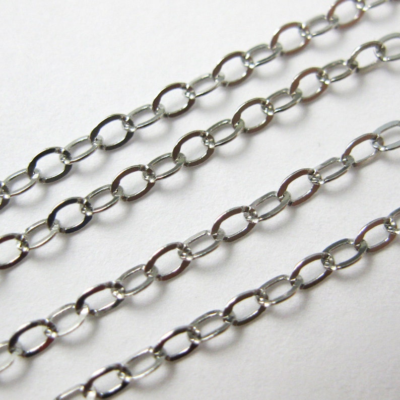 May include: Silver chain with oval links. The chain is shown in three rows, with the top row being the thickest and the bottom row being the thinnest.