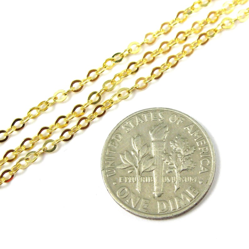 May include: Gold chain necklace with oval links, shown next to a US dime for scale.
