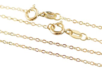May include: Close-up of several delicate gold-colored chain necklaces. Each chain features a small, oval link design and a secure clasp. The clasps are visible, with one marked "ITALY". The chains are displayed against a white background.