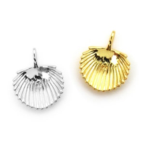 May include: Two scallop shell charms, one silver and one gold, with a loop at the top for attaching to jewelry.