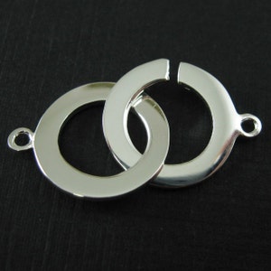 May include: Silver-toned metal connector with two interlocking circles. The connector has a smooth, polished finish.